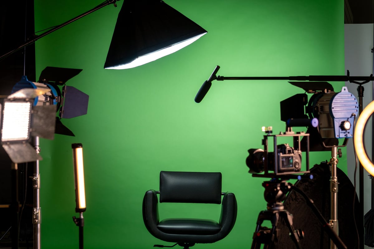 Empty studio with green screen, camera and lighting setup